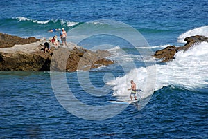 Standup paddle boarder surfing off Heisler Park, Laguna Beach, California.