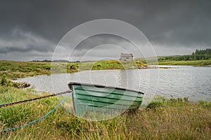 Paddle boat and house on the edge of Ballynahinch Lake in Connemara