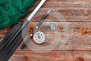 Paddle fishing rod and fishing net on a wooden background top view. Fishing hobby vacation concept. Copy space