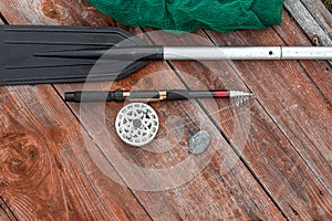 Paddle fishing rod and fishing net on a wooden background top view. Fishing hobby vacation concept. Copy space