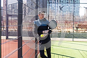 paddle player resting against the wall entertained by the ball