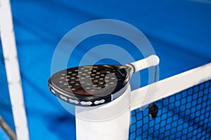 Paddle tennis: Paddel racket and ball in front of an outdoor court photo