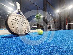 Paddle tennis racket, ball and net on the court