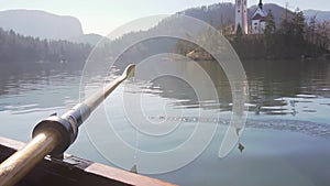 A paddle in the water on a sunny day - rowing the boat with island lake Bled in the background- lake Bled, Slovenia