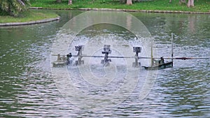 The Paddle wheel aerator active in pond for increase dissolve oxygen in water in the park. Water turbines are working to help keep