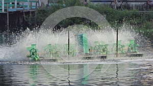 Paddle wheels aerators in black water on canal.