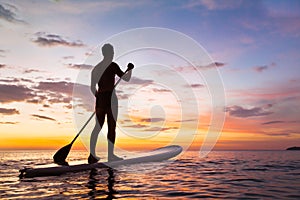 Paddleboard on the beach at sunset, SUP, leisure activity