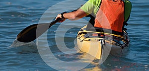 A paddler races his ocean kayak