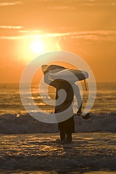 Paddler with surfski on shoulder at sunrise