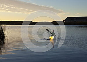 Paddling canoe at sunset