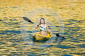 Paddling a kanu kayak in golden sunset ocean waters