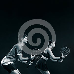 Padel tennis doubles. Two athletes players with racket. Man and woman with paddle racket on court. Sport concept. Social