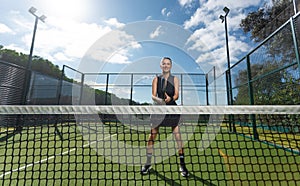 Padel tennis player with racket in action on the court. Woman athlete with paddle racket on court outdoors. Sport