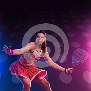 Padel tennis player with racket on tournament. Girl athlete with paddle racket on court with neon colors. Sport concept