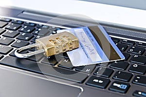 Padlock and banking card lying on computer keyboard symbolizing secure online banking or shopping