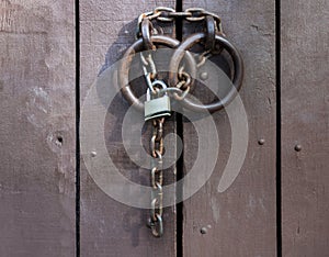 The padlock on the chain closed the old door