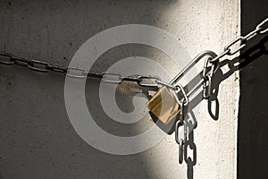 Padlock and chain isolated on wall background