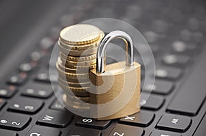 Padlock and coins on laptop keyboard