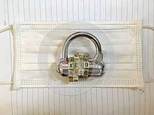 Padlock combination lock on white surgical medical masks for lockdown like coronavirus covid 19