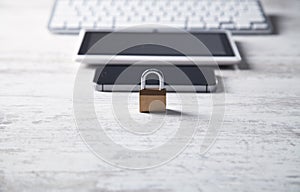 Padlock with computer keyboard, smartphone and tablet. Internet and technology security