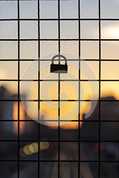 Padlock on the gate in front of a sunset photo