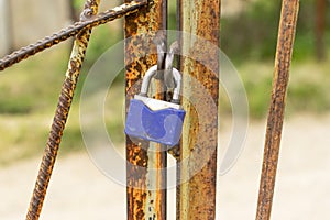 A padlock hangs on a rusty gate. Security concept, data protection, password and account hacking. Pick up the keys for the lock.