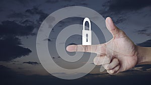 Padlock icon on finger over sunset sky, Technology internet security and safety online concept