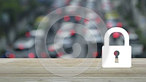 Padlock icon on wooden table over blur of rush hour with cars and road in city, Technology internet security and safety onlin