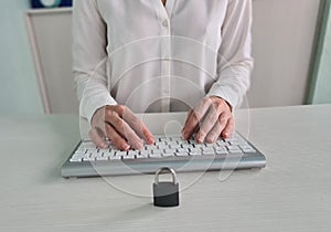Padlock on laptop computer keyboard and female manager in background
