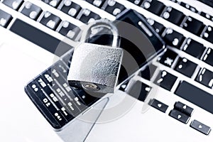 Padlock on laptop and old mobile phone. Internet data privacy information security concept. Antivirus and malware defense