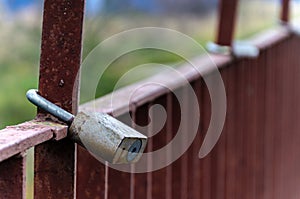 padlock on a metal fence. background red. old rusty fence. Love and harmony for life. amulet from evil