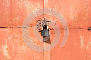 Padlock on an old orange garage door