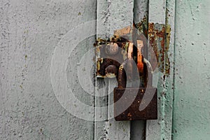 Padlock old and rusty on the background of an iron gate close-up