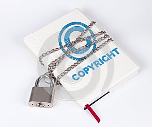 A padlock protects the book in a concept with COPYRIGHT text and