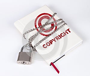 A padlock protects the book in a concept with COPYRIGHT text and