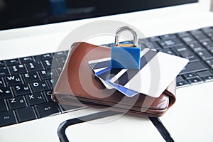 Padlock, wallet and credit cards on the computer keyboard. Credit card security