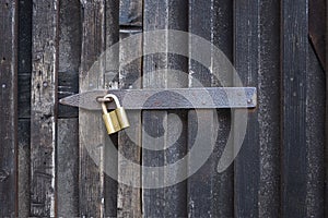 Padlock on a wooden wall. On wooden gates.