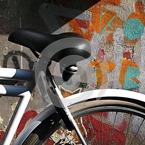 A Padlocked Bicycle Against a Graffiti Painted Wall