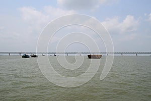 Padma River landscape and Padma Multipurpose bridge. Wood boat in the river.