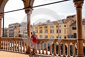 Padua -  Tourist woman enjoying the view on Piazza delle Erbe from the loggia of Palazzo della Ragione in Padua, Veneto, Italy