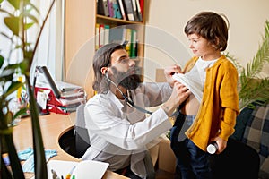 Paediatrician doctor examining a child in comfortabe medical office