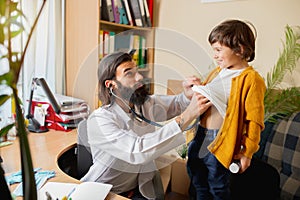 Paediatrician doctor examining a child in comfortabe medical office