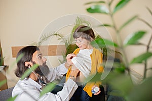 Paediatrician doctor examining a child in comfortabe medical office