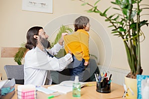 Paediatrician doctor examining a child in comfortabe medical office