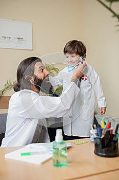 Paediatrician doctor examining a child in comfortabe medical office