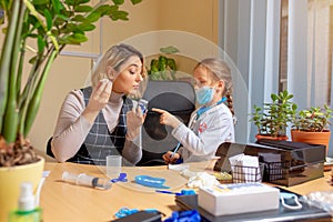 Paediatrician doctor examining a child in comfortabe medical office. Little girl playing pretends like doctor for woman