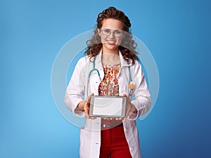 Paediatrician doctor showing tablet PC blank screen on blue