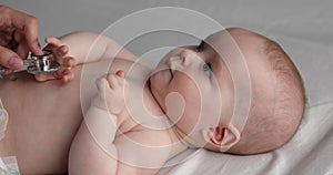 Paediatrician examining baby kid with stethoscope, close up view