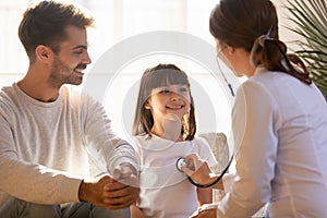 Paediatrician holding stethoscope listening heart sounds of little girl