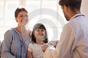 Paediatrician male doctor writing patient information focus on little girl